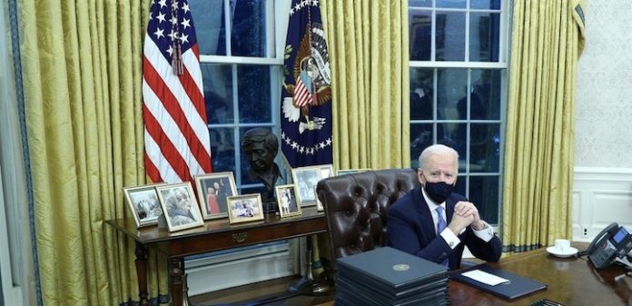 U.S. President Joe Biden signs executive orders inside the Oval Office at the White House in Washington